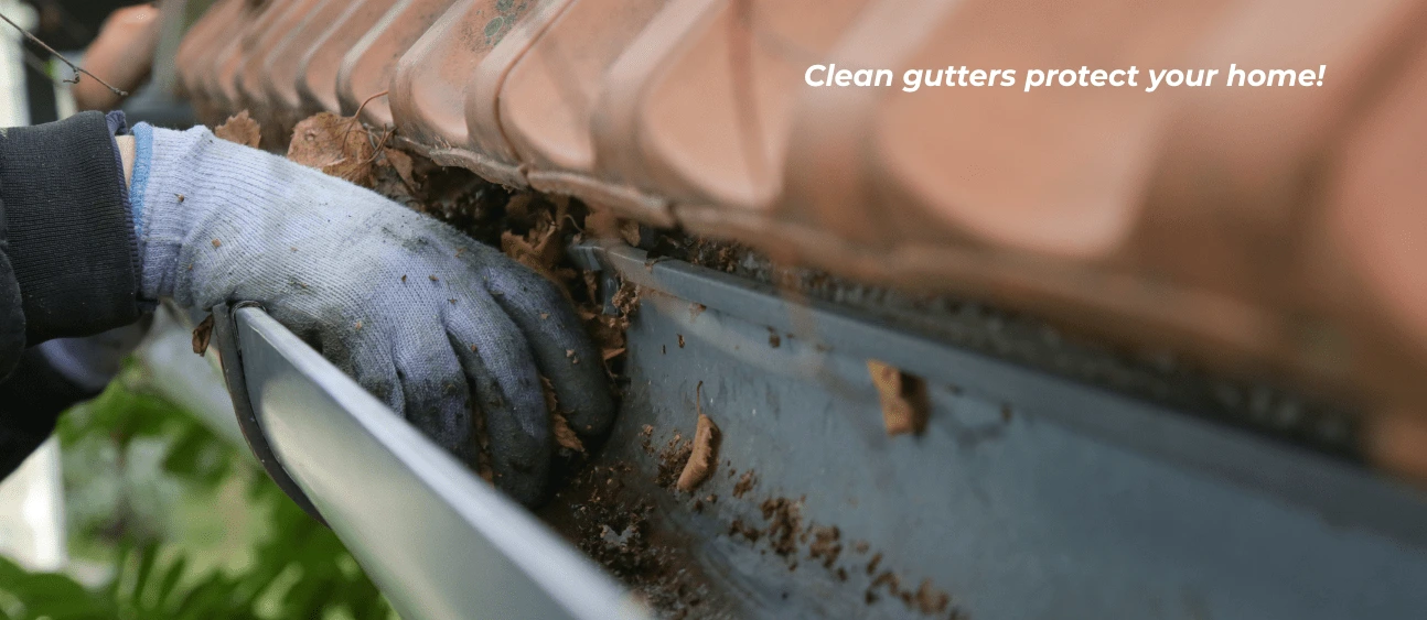 Gutter cleaner clearing out gutters by hand