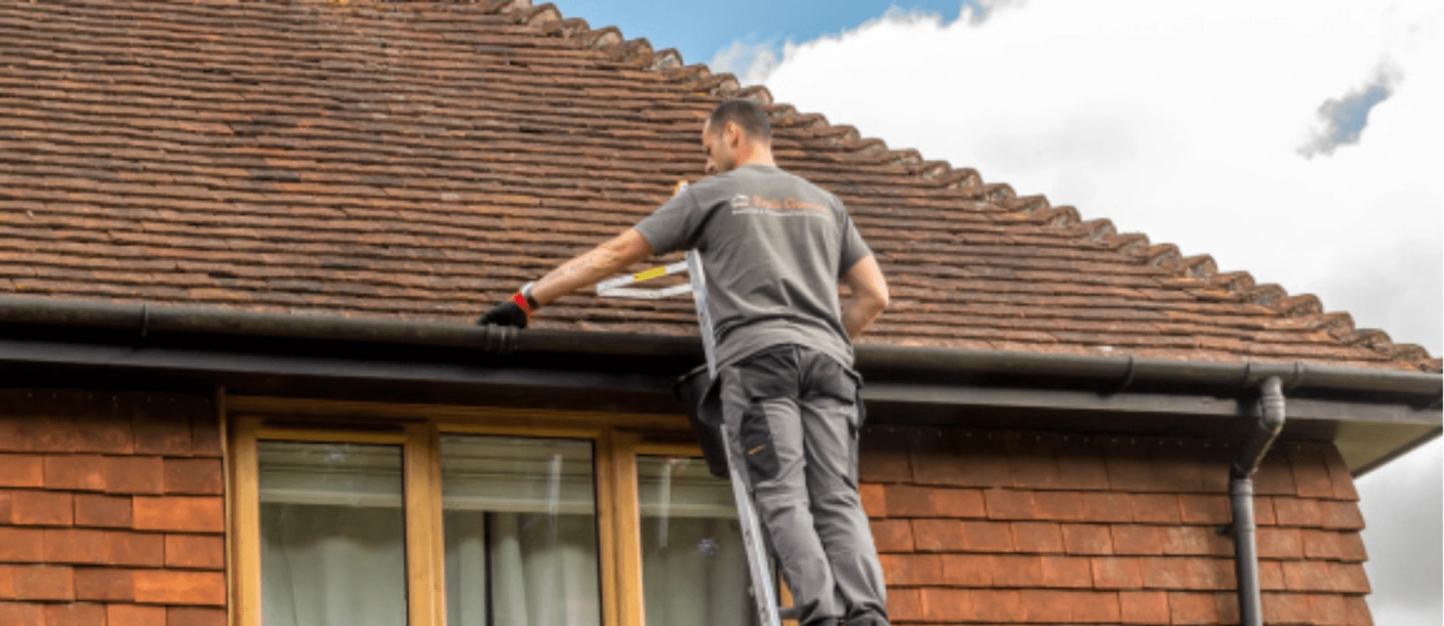 Gutter cleaner on ladder cleaning by hand
